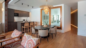 A modern kitchen with a dining area, wooden flooring, and a large window. - Genteel Home Tomás de Ibarra 15 (Seville)