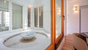 A modern interior with a stone fountain, large windows, and a wooden door. - Genteel Home Tomás de Ibarra 15 (Seville)