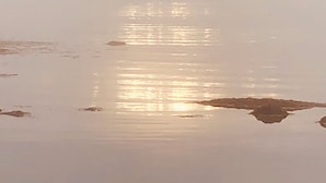 Tyyni vesialue, joka heijastaa taivasta.