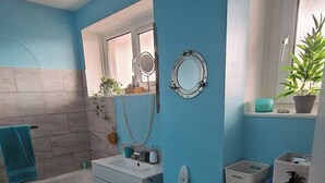 Un baño pequeño con bañera, inodoro y lavadora.