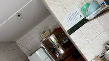 Cozinha com geladeira, armários de madeira e painel de azulejos.