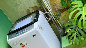 Un condizionatore portatile bianco con display digitale, collegato a una presa a muro.