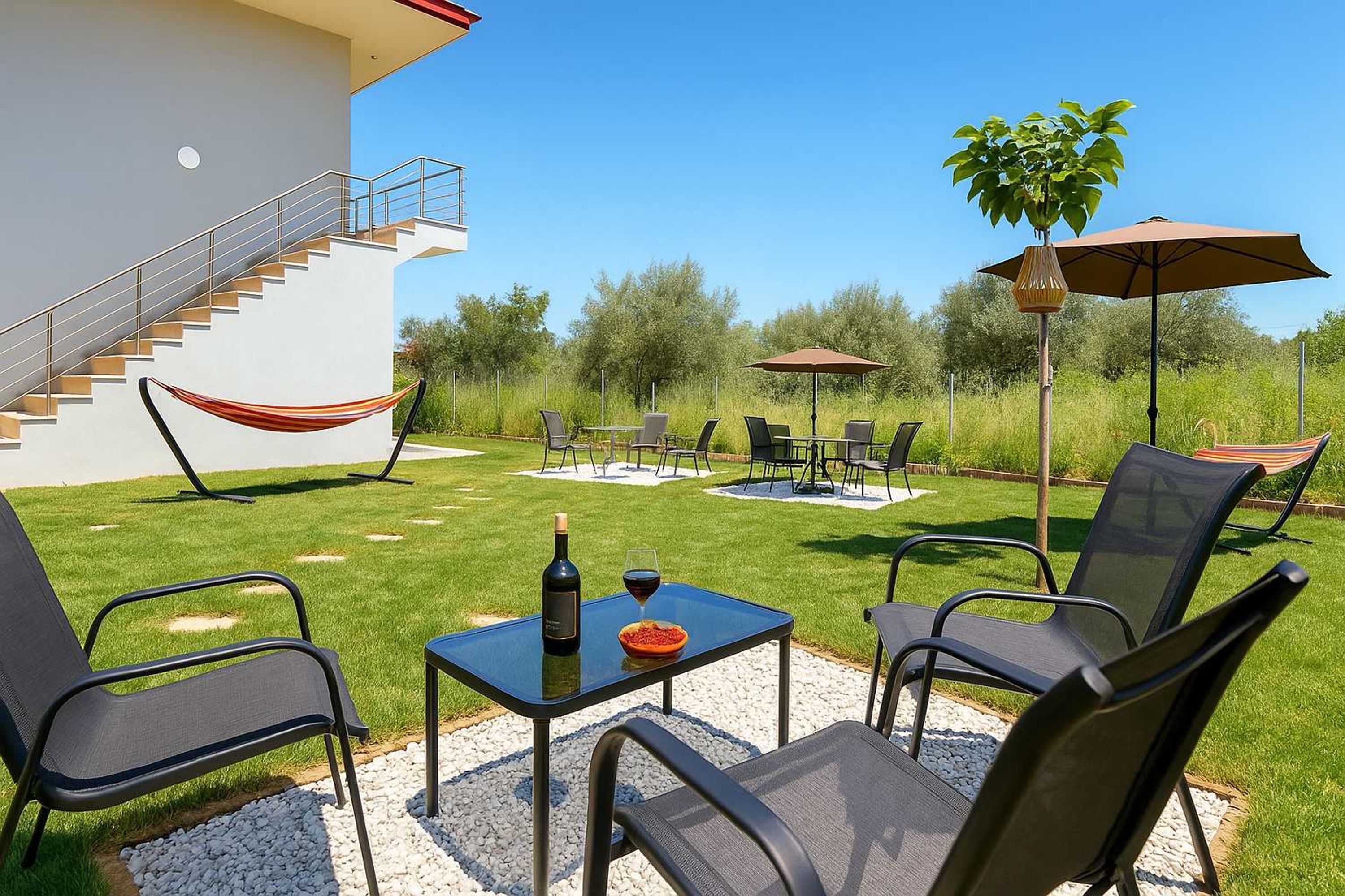 An outdoor patio with a table set for two, a hammock, and outdoor seating.