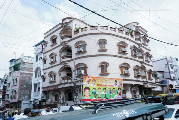 Ein mehrstöckiges Gebäude mit Balkonen und einem großen Plakat an der Fassade.