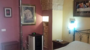 A bedroom with a bed, a nightstand, a dresser, and a lamp.