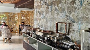 A restaurant with a buffet setup, including a variety of dishes and utensils on display. - Inn Of Joy (Noida)
