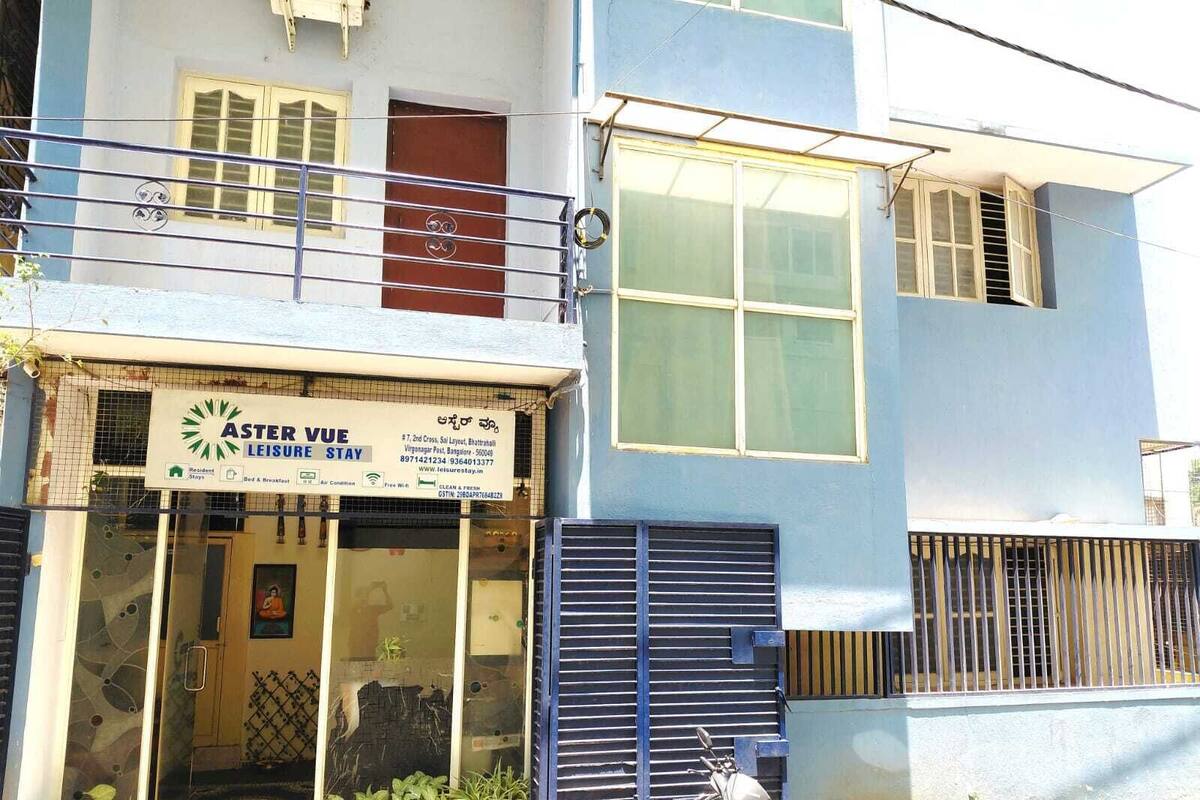Un edificio de dos pisos con un letrero que dice 'ASTER VUE LEISURE STAY', indicando que es una casa de huéspedes o un pequeño hotel.