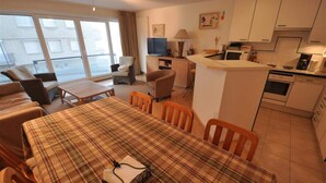 A modern apartment with a dining area, kitchen, and seating space. - Apartment in Duinbergen With Side Sea View (Knokke-Heist)