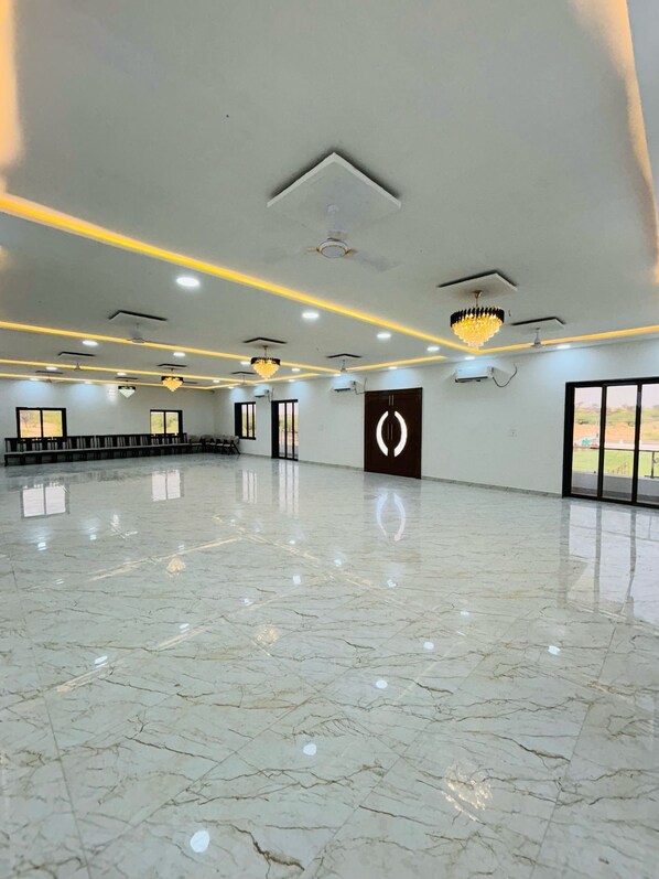 A spacious, well-lit indoor area with a polished marble floor, ceiling lights, and a modern chandelier. - Hotel Shri Tulsi Residency (Phalodi)