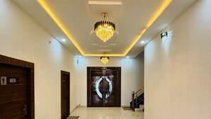 A spacious hallway with a marble floor, a chandelier, and a door labeled "MEN". - Hotel Shri Tulsi Residency (Phalodi)