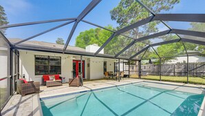 A covered outdoor swimming pool with a patio area, including seating and a table. - Private Pool & Patio: Niceville Family Home (Niceville)
