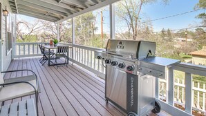 A covered outdoor deck with a grill, seating area, and a view of the surrounding landscape. - Walk to Dtwn Show Low: Townhome w/ Balcony (Show Low)