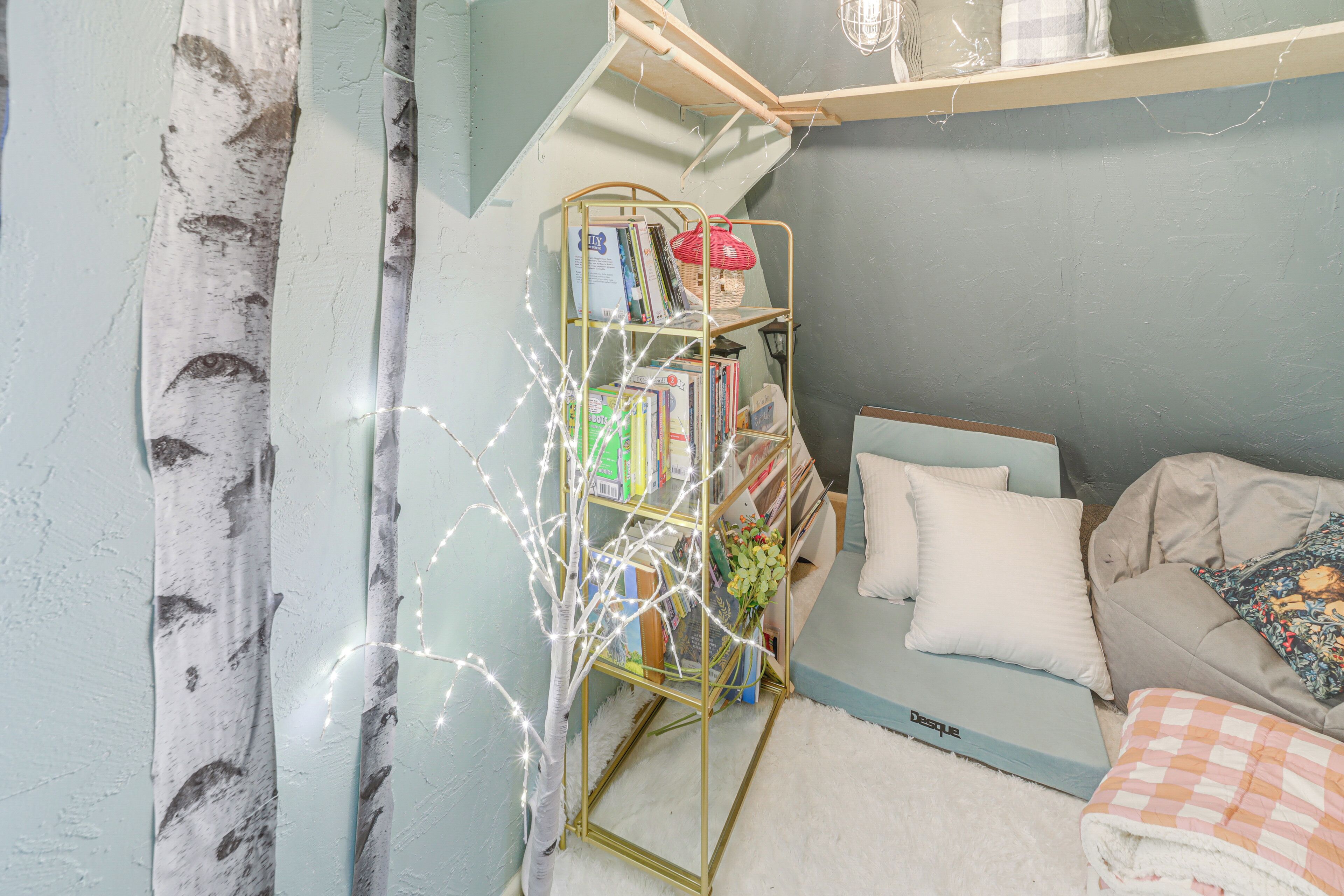 A cozy bedroom with a bookshelf, a bed, and a window with curtains.