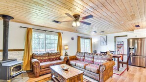 Un salon chaleureux avec une cheminée, des meubles en bois et une grande fenêtre.