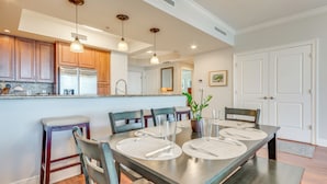A modern kitchen with wooden cabinets, stainless steel appliances, and pendant lighting. - Sunset-view Resort Condo on Perdido Key (Pensacola)