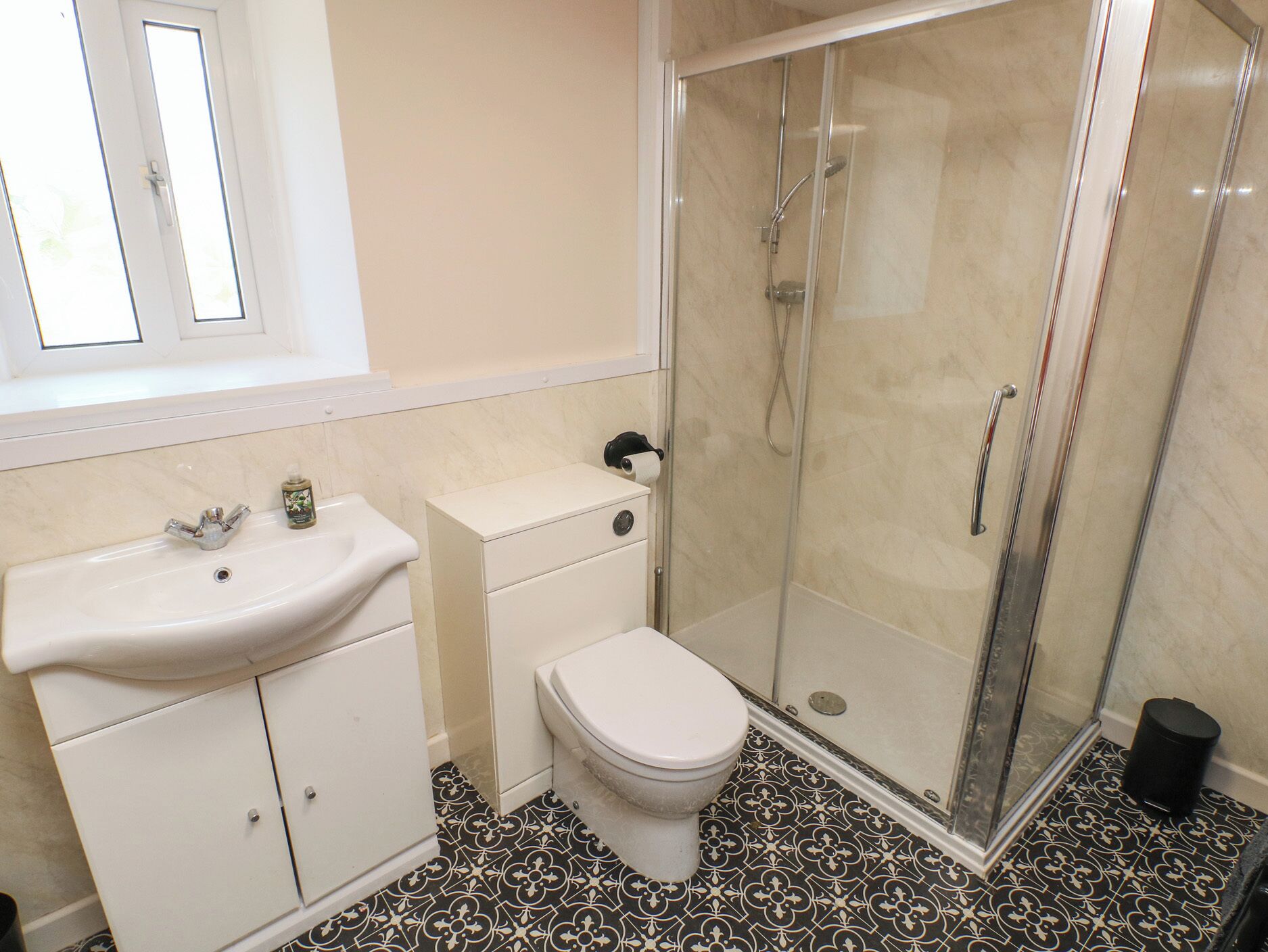 Een badkamer met wastafel, toilet en douchecabine.