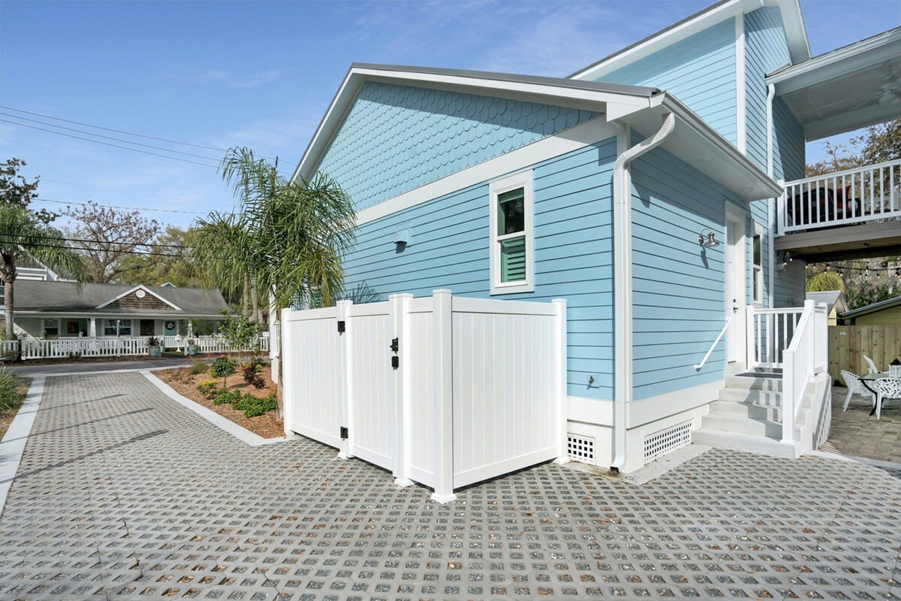 A two-story house with a blue exterior and a white porch.