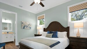 A bedroom with a bed, nightstands, a ceiling fan, and a window with blinds. - Downtown St Augustine Steps to Ice Plant Upscale (St. Augustine)