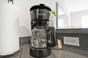 A BLACK+DECKER coffee maker on a kitchen counter with a roll of paper towels and a jar of sugar. - Just North of Downtown Fenced Yard BBQ Patio (St. Augustine)