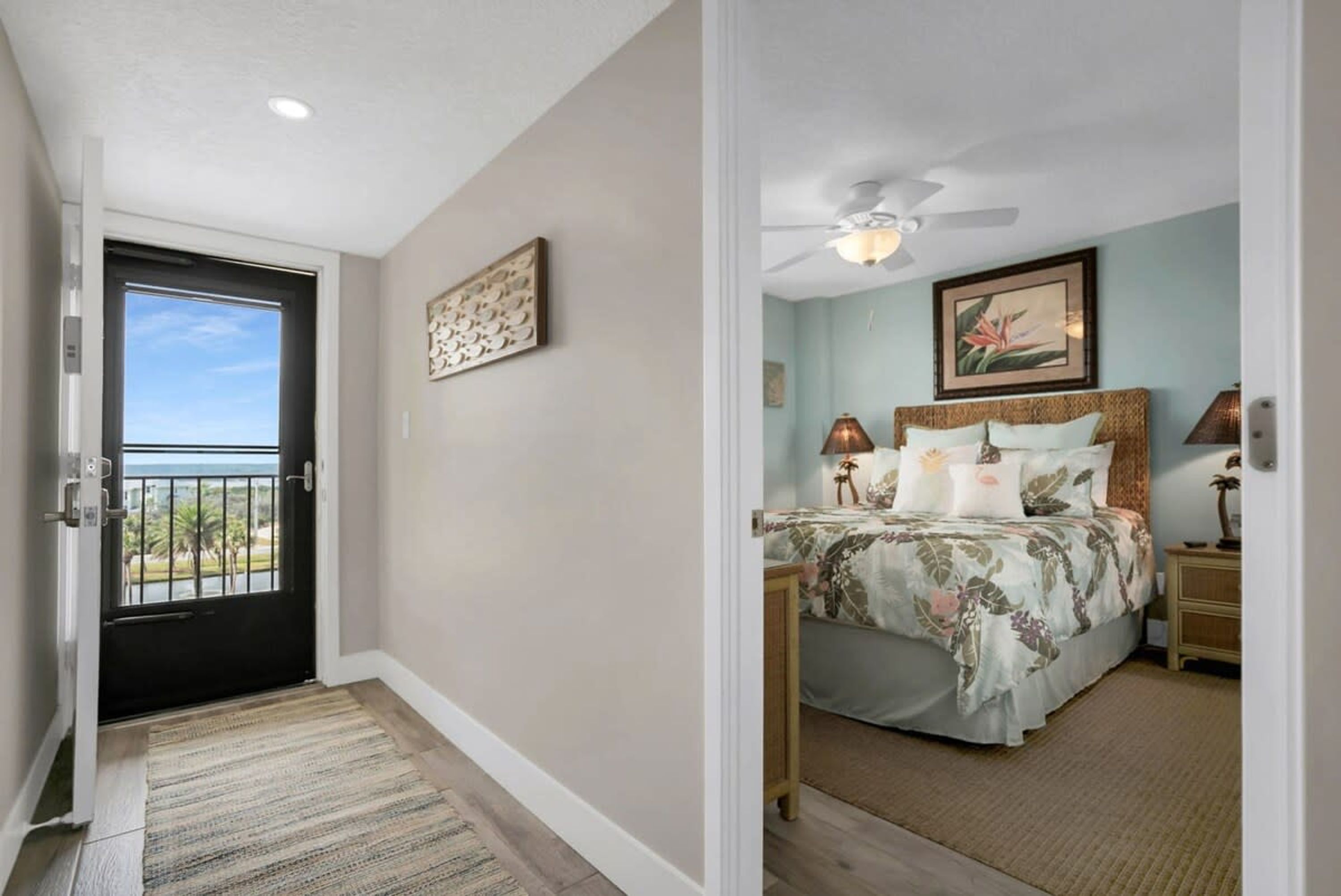 A bedroom with a bed, a ceiling fan, and a door leading to a balcony.