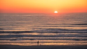 A sunset over the ocean with a person standing on the beach. - 100 Steps to Sand Free Parking Smart TV Patio (St. Augustine)