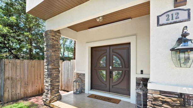 A house with a stone pillar, a double door with glass panels, and a number '212' sign. - Pool Hot Tub Dock Walk to Beach Beach Gear (St. Augustine)