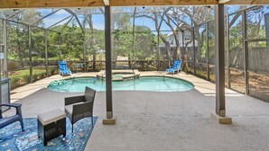 A covered outdoor area with a pool, lounge chairs, and a patio table. - Pool Hot Tub Dock Walk to Beach Beach Gear (St. Augustine)