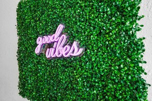 A neon sign with the text "good vibes" on a wall covered with green foliage. - Heated Pool Tiki Lounge Steps to Beach Games (St. Augustine)