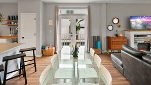 Ein modernes Wohnzimmer mit einem Glastisch, einer Ledersofa und einem Fernseher.