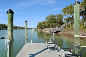 A dock with chairs and a rope ladder leading to a wooden dock. - On the Canal New Dock Kayak Bikes Beach Gear (Palm Coast)