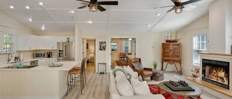 A spacious living area with a fireplace, a dining area, and a kitchen with modern appliances.