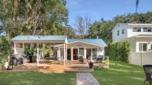 Uma casa com alpendre coberto, espaço para churrasco e gramado bem cuidado.