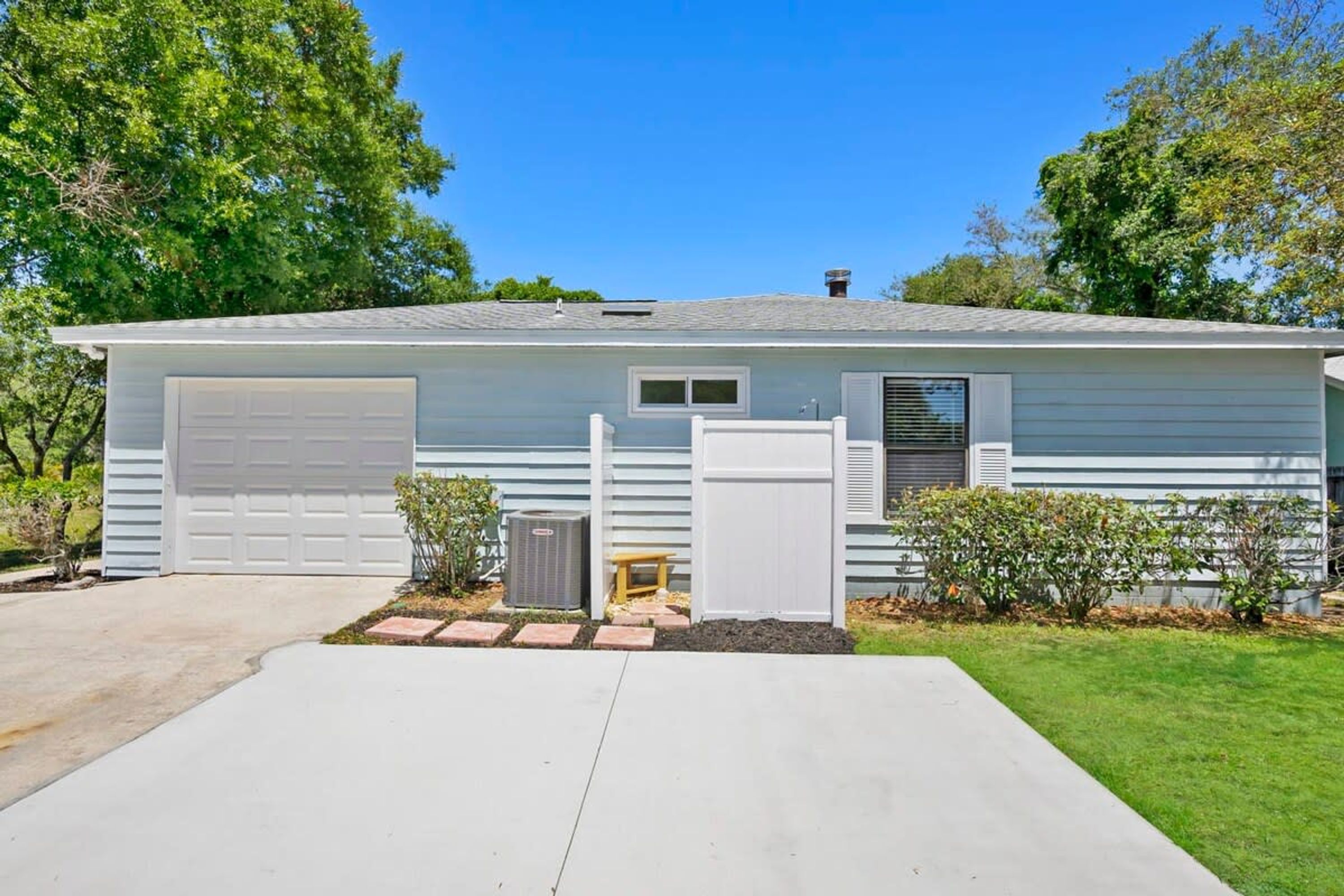 A single-story house with a garage, a small porch, and a well-maintained lawn.