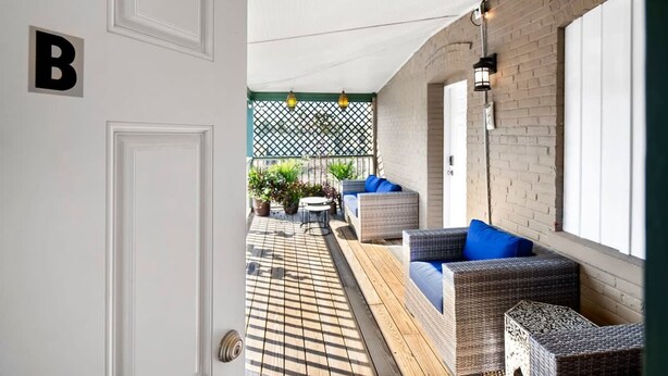 A covered outdoor seating area with wicker furniture and a tiled floor. - Free Parking Big Patio Next to Restaurants Bars (St. Augustine)