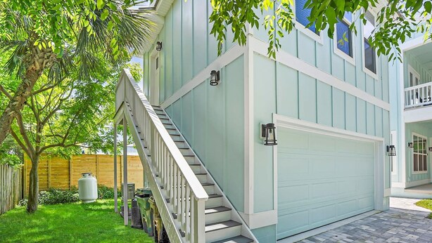 A two-story house with a light blue exterior, a covered porch, and a staircase leading to the upper floor. - Downtown St Augustine Apt Smart TV Pack N Play (St. Augustine)