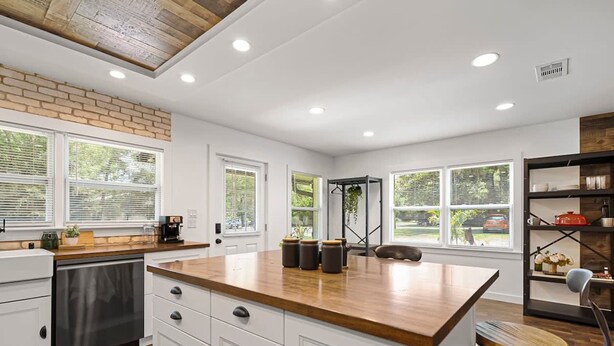 A modern kitchen with white cabinetry, a wooden countertop, and a built-in island. - Beautiful Kitchen BBQ Outdoor Dining Big Yard (St. Augustine)