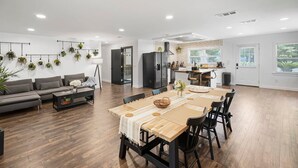 A modern living room with a dining area, a kitchen, and a large window. - Beautiful Kitchen BBQ Outdoor Dining Big Yard (St. Augustine)