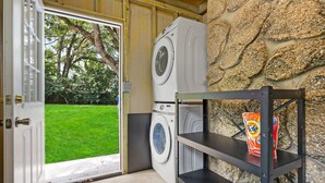 A laundry room with a washing machine, a dryer, and a shelf with a detergent box. - Beautiful Kitchen BBQ Outdoor Dining Big Yard (St. Augustine)