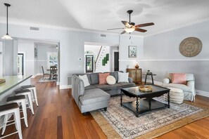 Relax in this stylish living area with a sofa, coffee table, and dining bar.