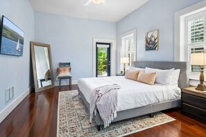 Relax in a classic bedroom with a large bed, nightstand, and dresser, and access to an outdoor area.