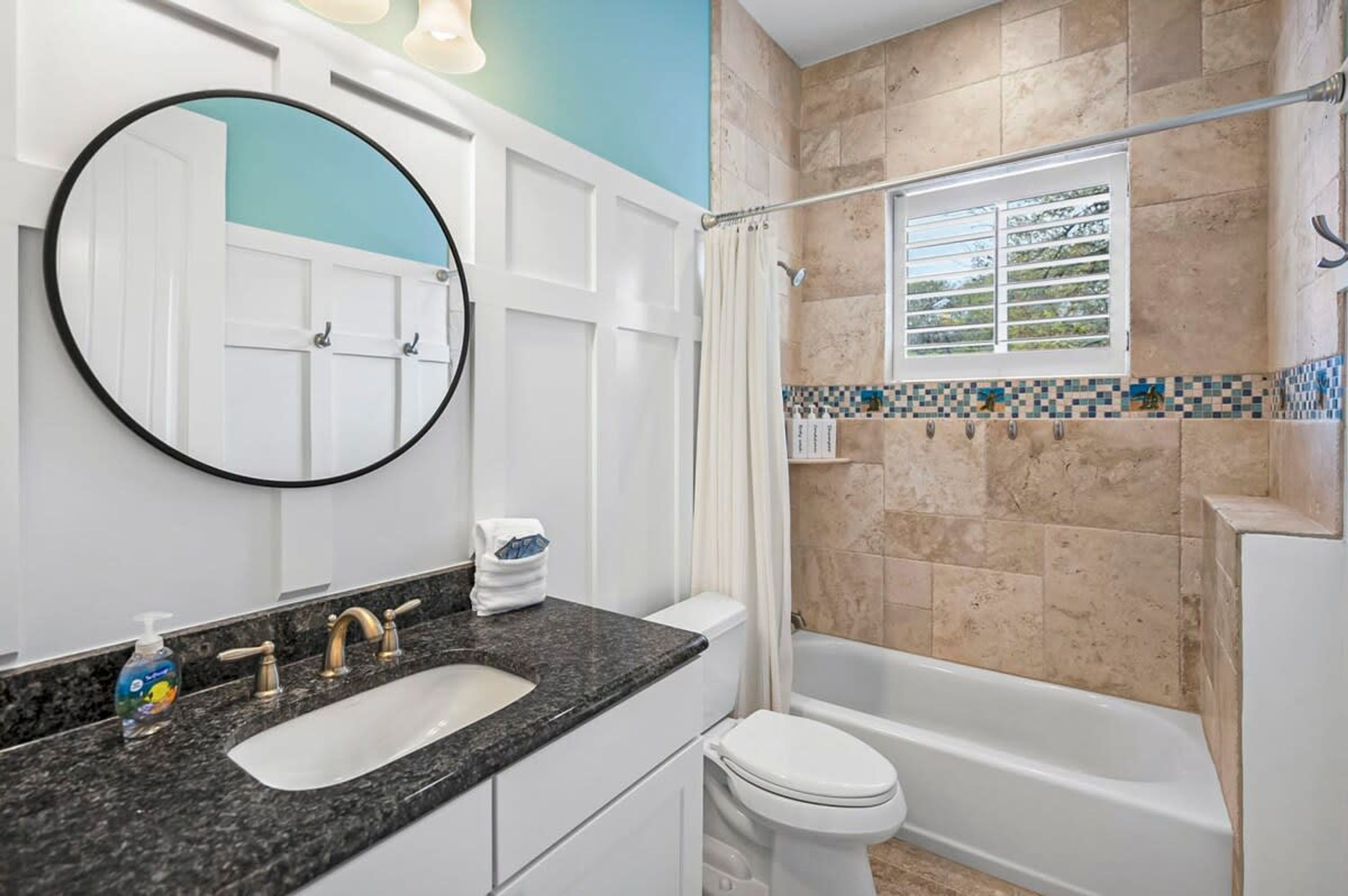 Une salle de bain avec un lavabo, des toilettes et une baignoire.