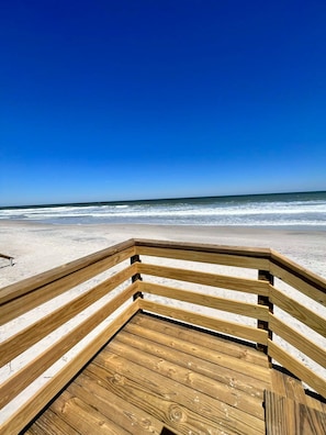 A wooden deck leading to a beach with a clear blue sky. - Pool Steps to Sand Near Downtown Beach Gear (St. Augustine)