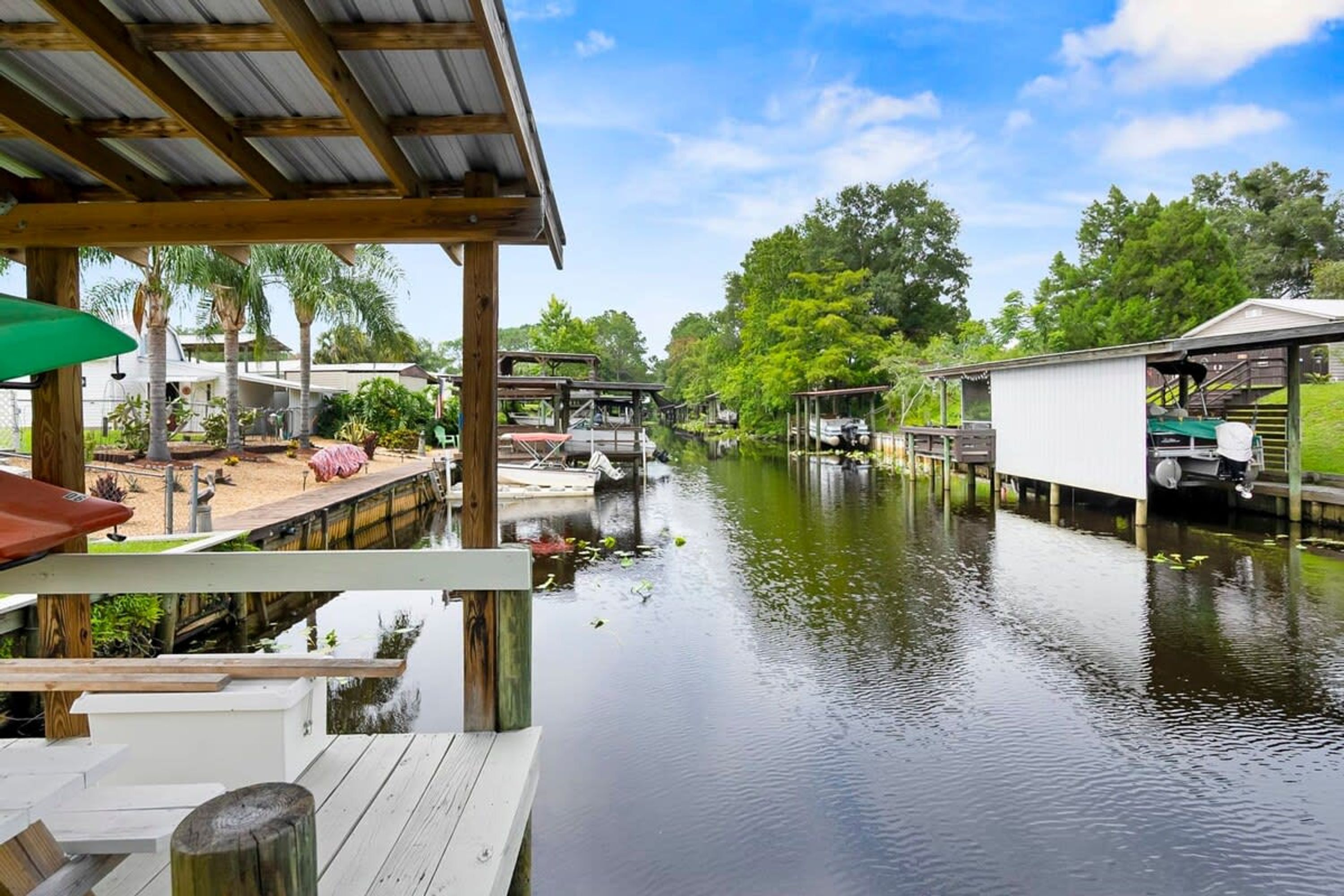 A riverside dock with wooden structures and a covered seating area.