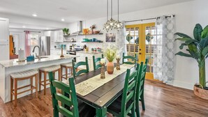 Een moderne keuken met een centraal eiland, houten stoelen en een eettafel.