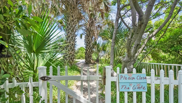 A gated pathway leading to a building with a sign reading "Please Close The Gate." - Welcome Basket Pool By Beach Fire Pit BBQ PS4 (St. Augustine)