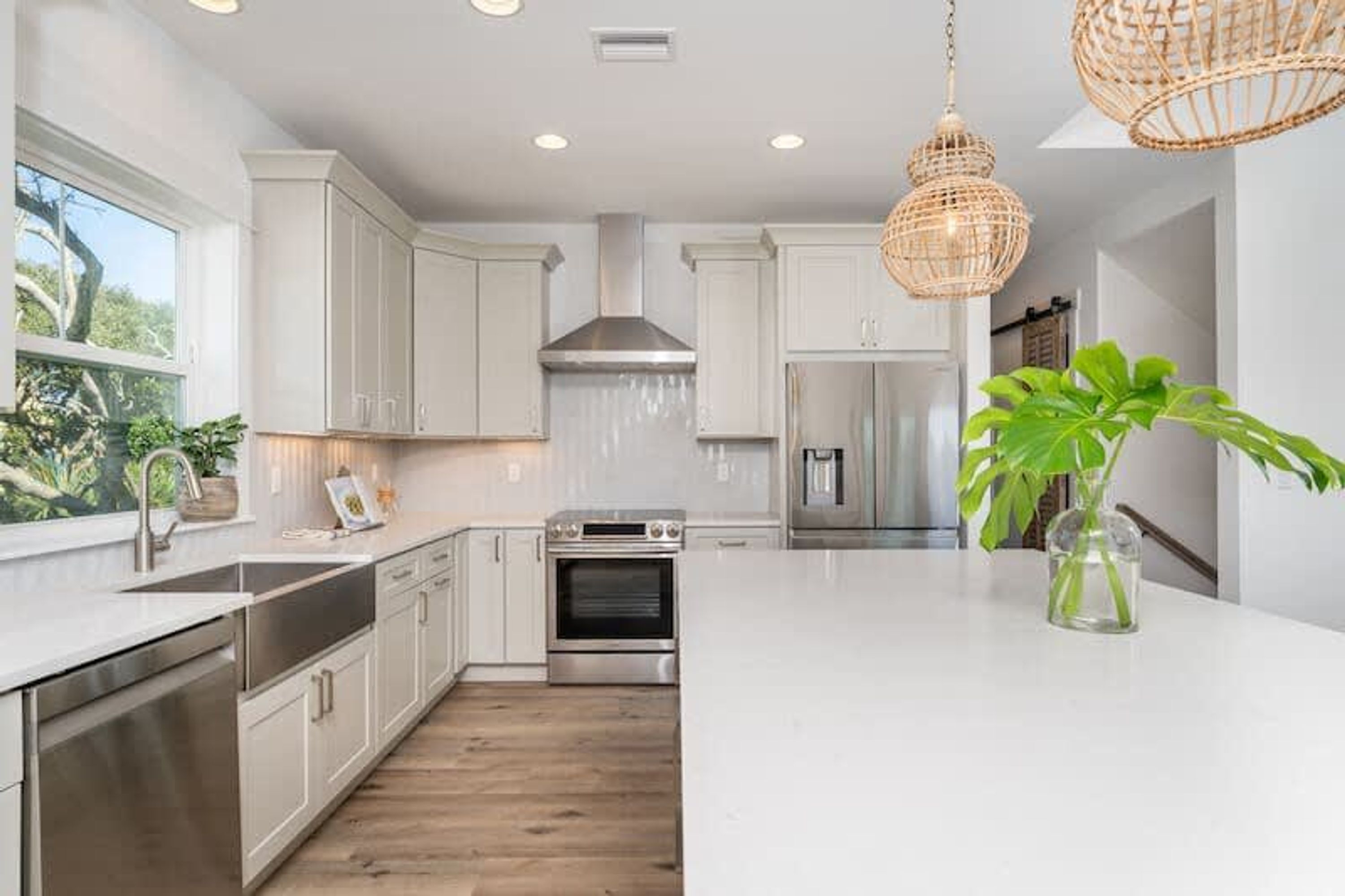 Una cocina moderna con armarios blancos, electrodomésticos de acero inoxidable y una isla grande.