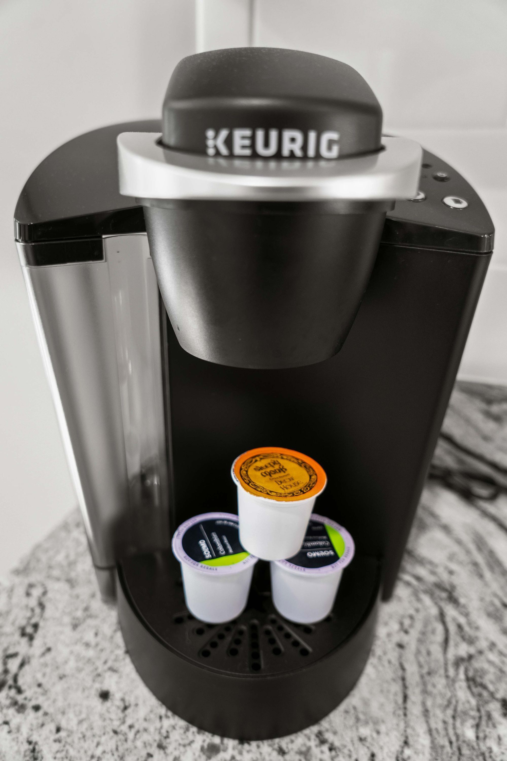 Keurig-kahvinkeitin, jonka tiputusalustalla on kaksi kertakäyttöistä kahvikapselia.