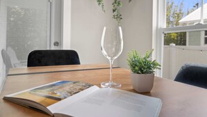 A wooden table with a glass of water, a book, and a small potted plant. - 5 Minutes to Beach and Downtown Fire pit Grill (St. Augustine)