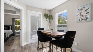 A dining area with a wooden table, black chairs, and a hanging plant. - 5 Minutes to Beach and Downtown Fire pit Grill (St. Augustine)