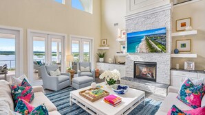 A spacious living room with a fireplace, large windows, and a view of the outdoors. - 400 Steps to Sand Waterfront Luxury w Dock Pool (St. Augustine)